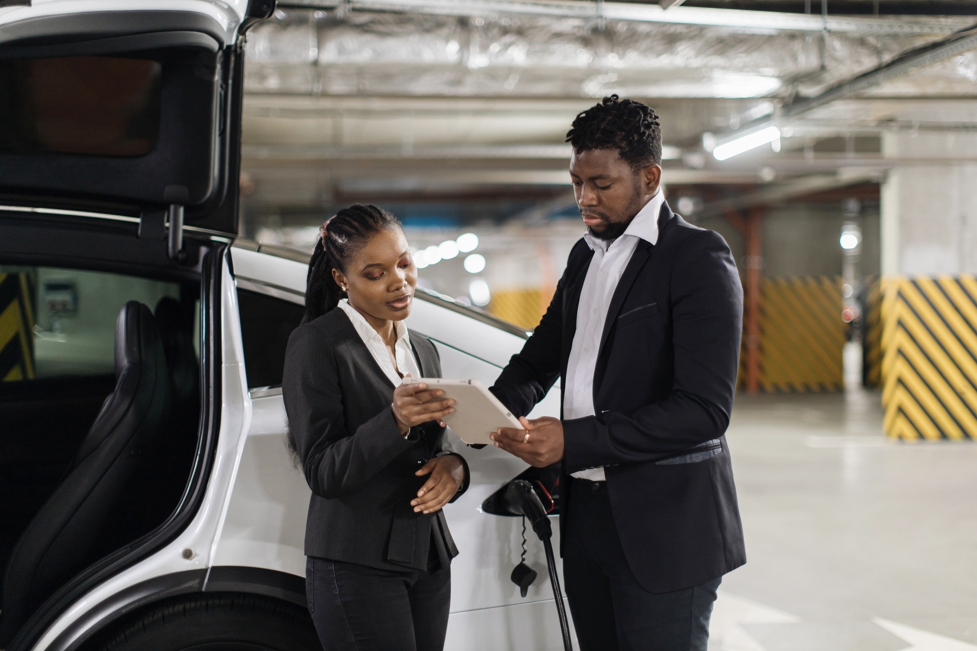 Male putting e-signature via tablet during e-car fill-up